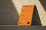 A copy of IET's 18th Edition Regulations Amendment 4 (an orange A4 book) leans against a stone wall.